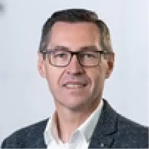 Portrait of a person with a blurred face, wearing a white shirt collar and a dark suit jacket