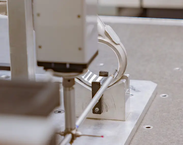 Nahaufnahme eines Messgeräts, das eine dünne Metallstange auf einer Halterung vermisst